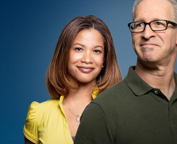 Two teachers stand against a blue gradient background