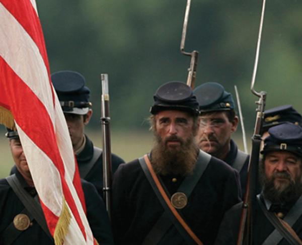 This is an image depicting a brigade of Union troops holding an American flag. 