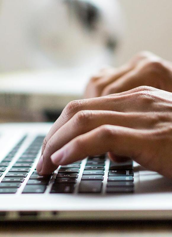 An online participant watches a webinar on their laptop.